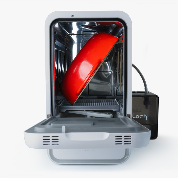 Small portable dishwasher with a red bowl inside on a white background